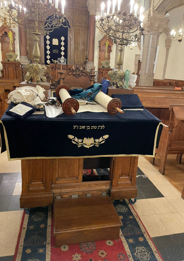 Photo d'une théba de la synagogue de Lyon, avec posé dessus des Sefer Torah
